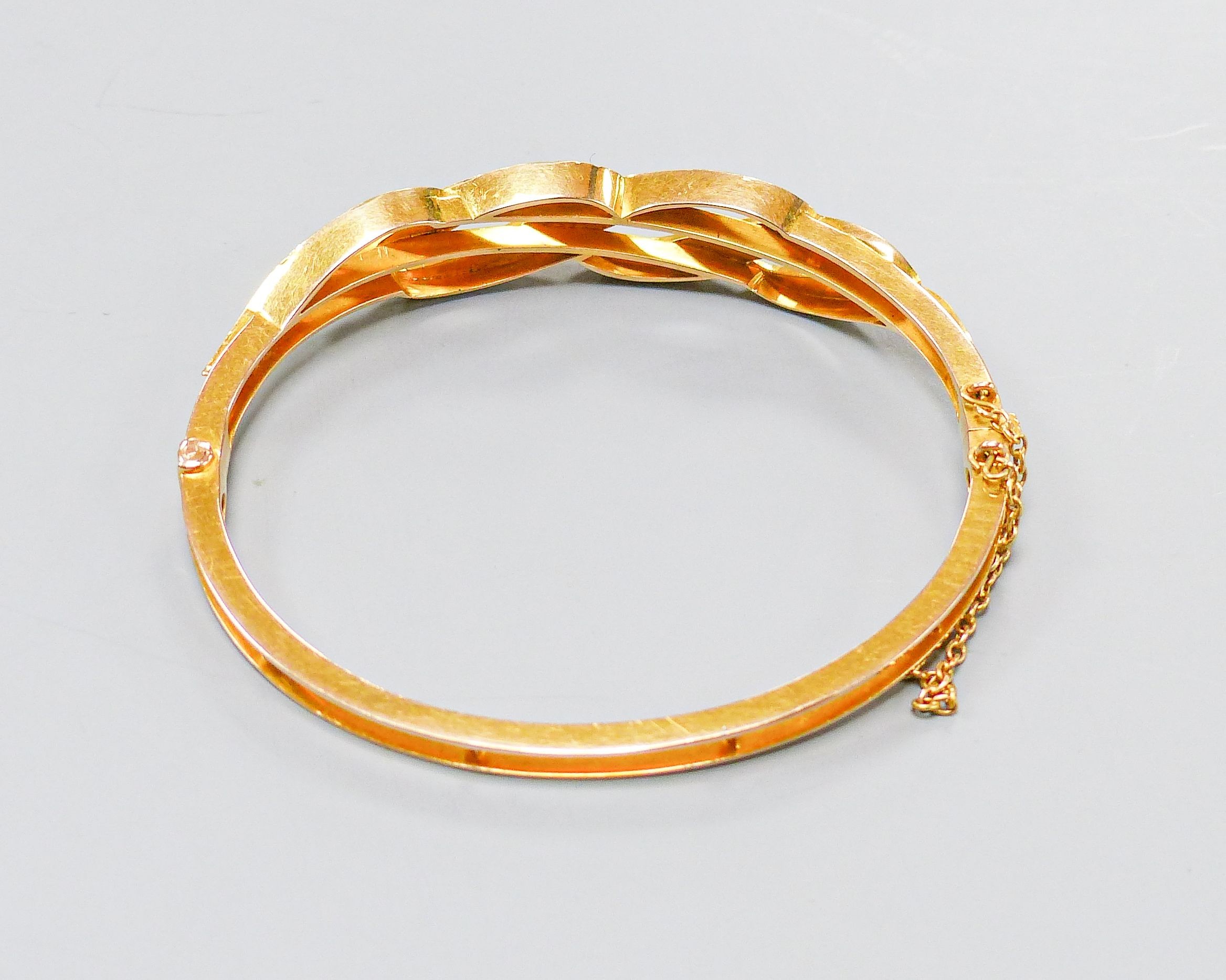 A boxed Edwardian yellow metal, graduated turquoise and seed pearl set hinged bangle, interior diameter 55mm, gross weight 15.5 grams.